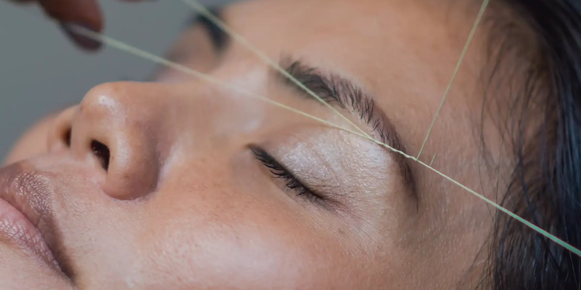 Gentle facial threading shaping eyebrows at Halo Beauty